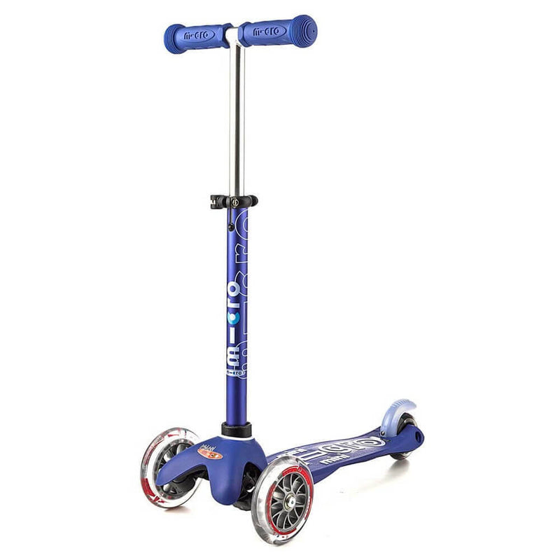 The Micro Mini Deluxe Scooter by Micro is blue, with an adjustable t-bar, T-shaped handlebar, two front wheels, one rear wheel, a logo-branded deck, and clear-rimmed wheels.