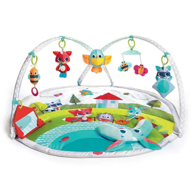 The Tiny Love Meadow Days Gymini Dynamic by Tiny Love is a colorful baby activity mat with a soft surface, animal designs, two adjustable arches, plush toys (fox, owl, bird, raccoon), and varied textures and patterns for sensory play.