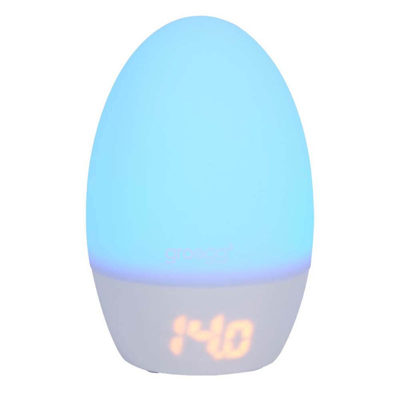 The Gro Company Tommee Tippee Gro Egg2 Digital Nursery Thermometer features an egg-shaped design, soft blue night light, orange LED display, and USB power for convenience, all shown against a white background.