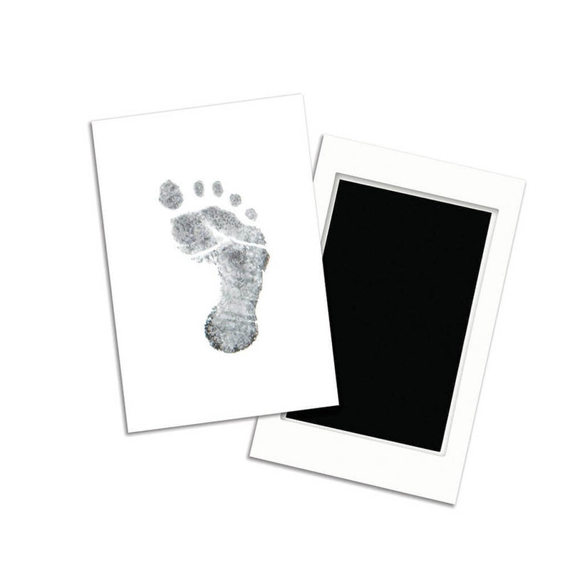 A black baby footprint is stamped on a white card next to an unused Pearhead Clean Touch Ink Pad. Both items from Pearhead are placed on a white background, creating a perfect newborn keepsake.