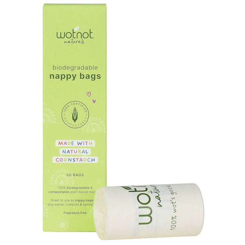 A green box of Wotnot Baby Bio Nappy Bags (by Wotnot), labeled GMO-free cornstarch, with purple and white text is shown with a roll of compostable bags positioned in front.