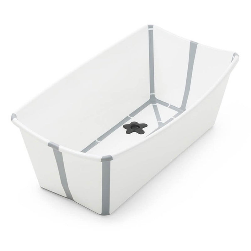 The Stokke Flexi Bath V2 by Stokke is a white, rectangular, foldable baby bath with gray-edge accents and a star-shaped, heat-sensitive drain plug at the bottom for added safety and convenience.