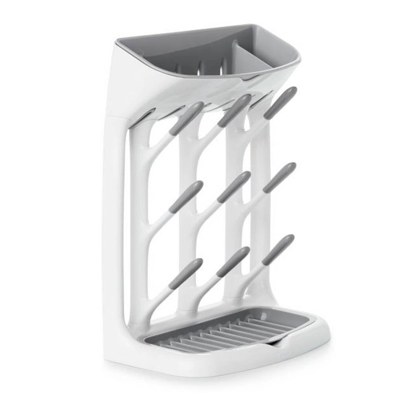 The OXO Tot Space Saving Drying Rack by Oxo Tot features angled pegs to hold bottles upright and a drip tray at the bottom to collect water, all in a compact white and gray design.