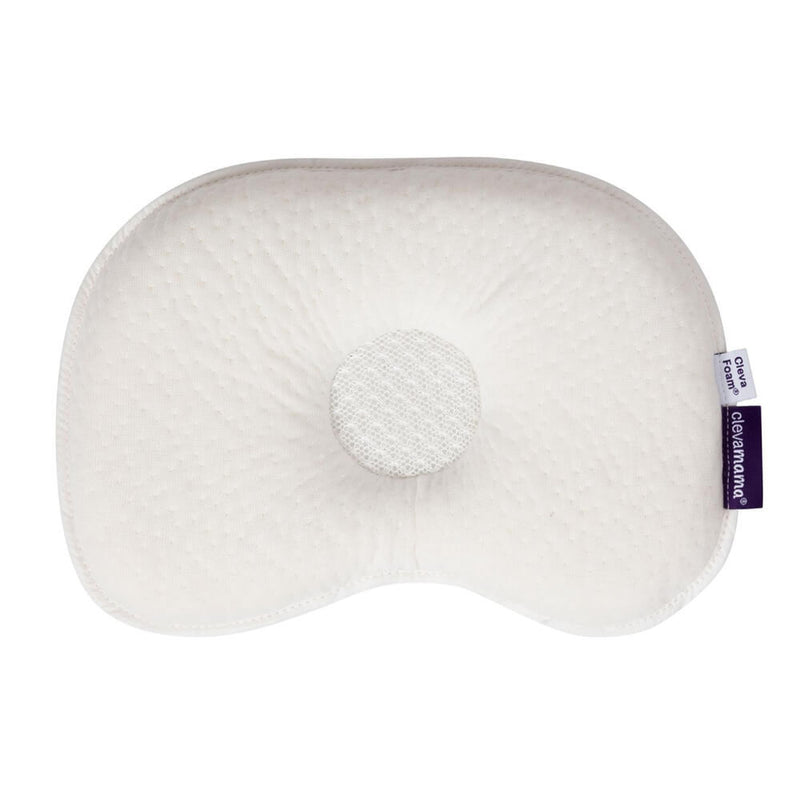 The Clevamama ClevaFoam Infant Pillow is a white, contoured baby pillow with a central circular indentation for head support, designed to prevent flat head syndrome and featuring a breathable, textured surface and a small right-edge fabric label.