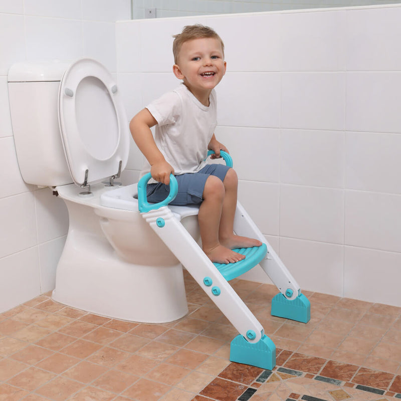 A smiling young boy sits on a toilet using the Dreambaby F6015 Step Up Toilet Topper from Dreambaby, a white and blue training seat with safety handles and a step ladder, making potty time easy in the tiled bathroom.