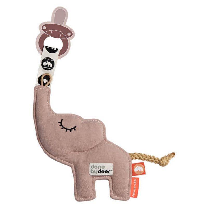 The Done By Deer Cozy Keeper by Done By Deer is a plush pink elephant-shaped pacifier holder with a closed-eye design, braided tail, fabric tags, and a ribbon for your baby's pacifier—perfect for keeping it cozy and close.