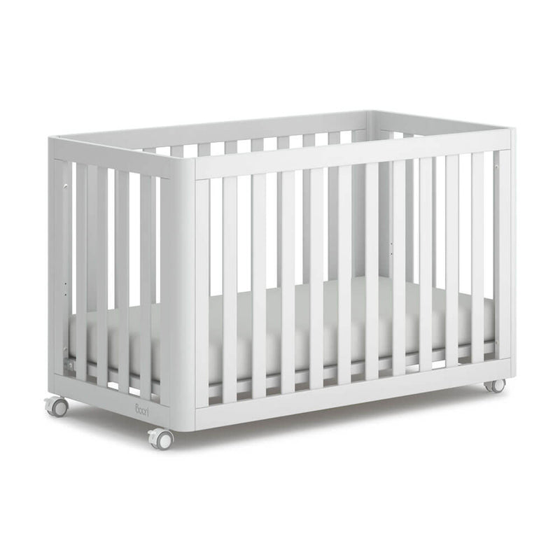 The Boori Turin Compact Cot Bed by Boori features a modern white finish, slatted sides, and four wheels. Shown with a white mattress against a plain white background, it’s ideal for minimalist, space-saving nurseries.