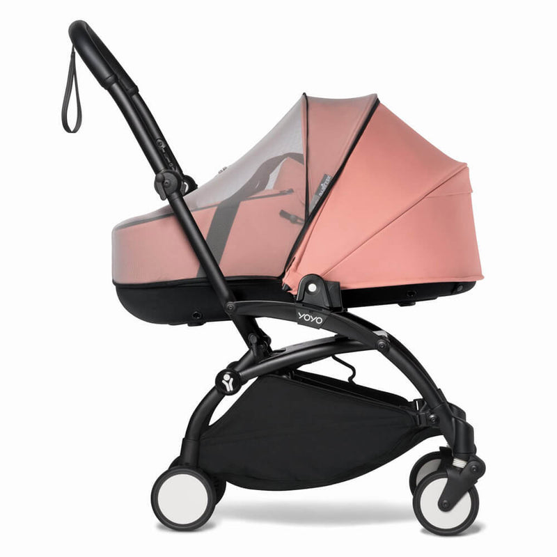 The BABYZEN YOYO stroller in side view features a pink canopy, black frame, storage basket, four wheels, wrist strap, and added protection with the Babyzen YOYO Mosquito Net for baby safety.