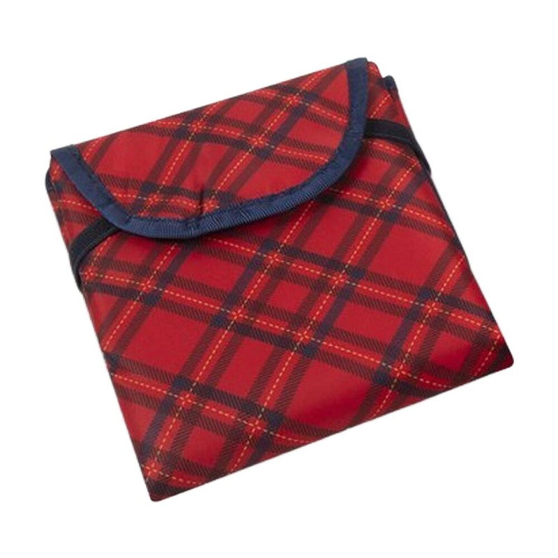 The Bonnie & Kind Change Mat by Bonnie & Kind is a folded picnic blanket in classic red and black tartan plaid with a flap and dark edging. It’s machine washable for easy care.