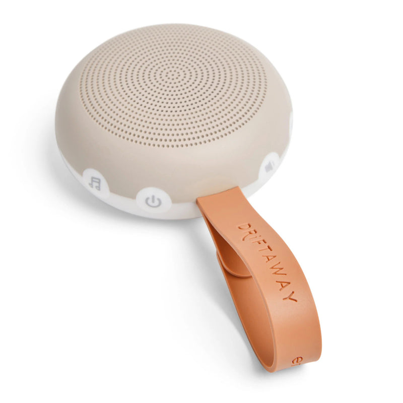 The ErgoPouch Drift Away White Noise Machine by ErgoPouch is a small, round, beige device with white buttons and a tan "DRIFT AWAY" strap—ideal for soothing sleep sounds and helping babies sleep anywhere.