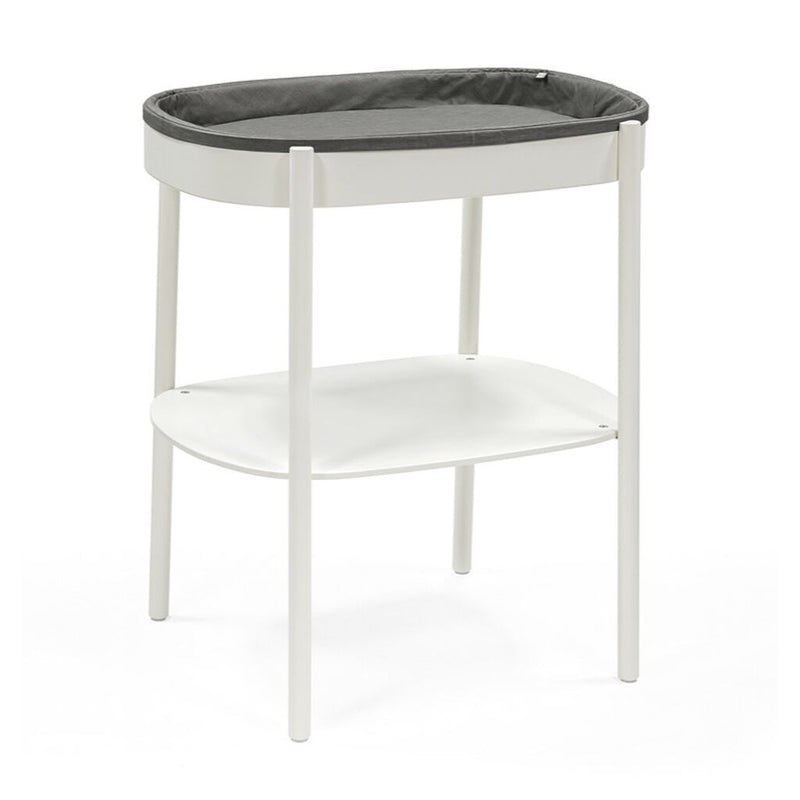 The Stokke Sleepi Changing Table V3 by Stokke features a modern Scandinavian design with four legs, a grey cushioned changing surface, and a lower storage shelf—perfect for adding style and function to any contemporary nursery.