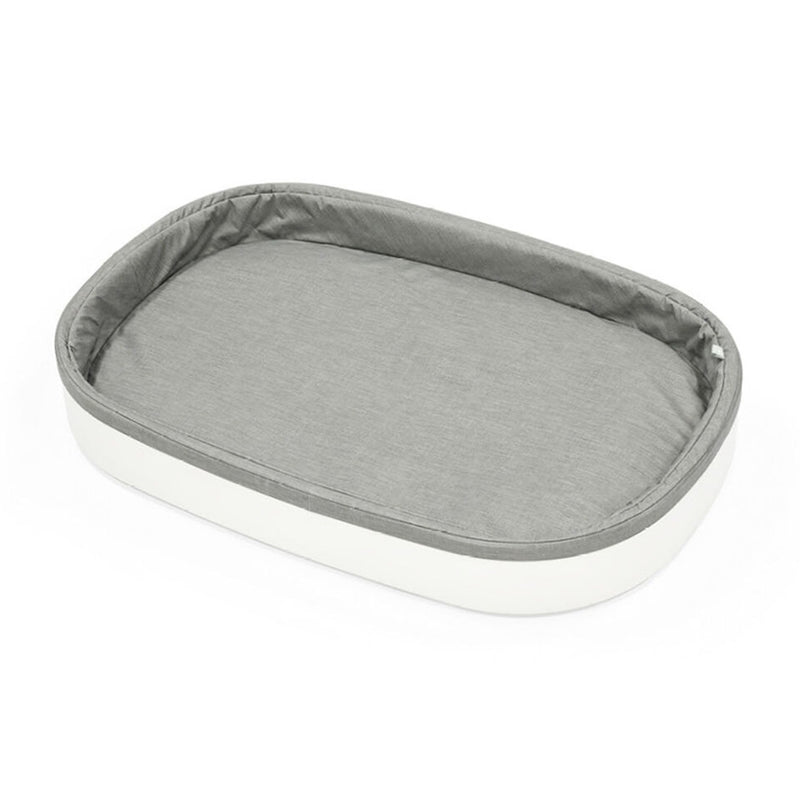 The Stokke Sleepi Changer V3 by Stokke is a rectangular changing pad with a soft, light gray cushioned interior, a white outer edge, and a water-repellent finish.