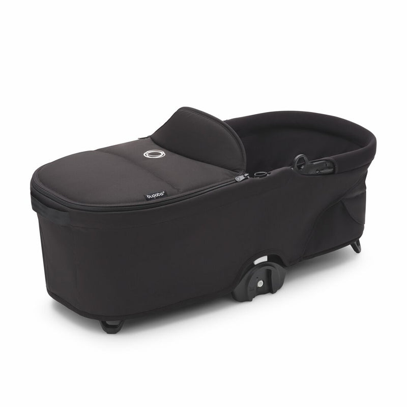The Bugaboo Dragonfly Bassinet Complete by Bugaboo features a black design, soft canopy, side handles, and small wheels for comfort and portability; its foldable build makes it ideal for strolls or naps on the go.