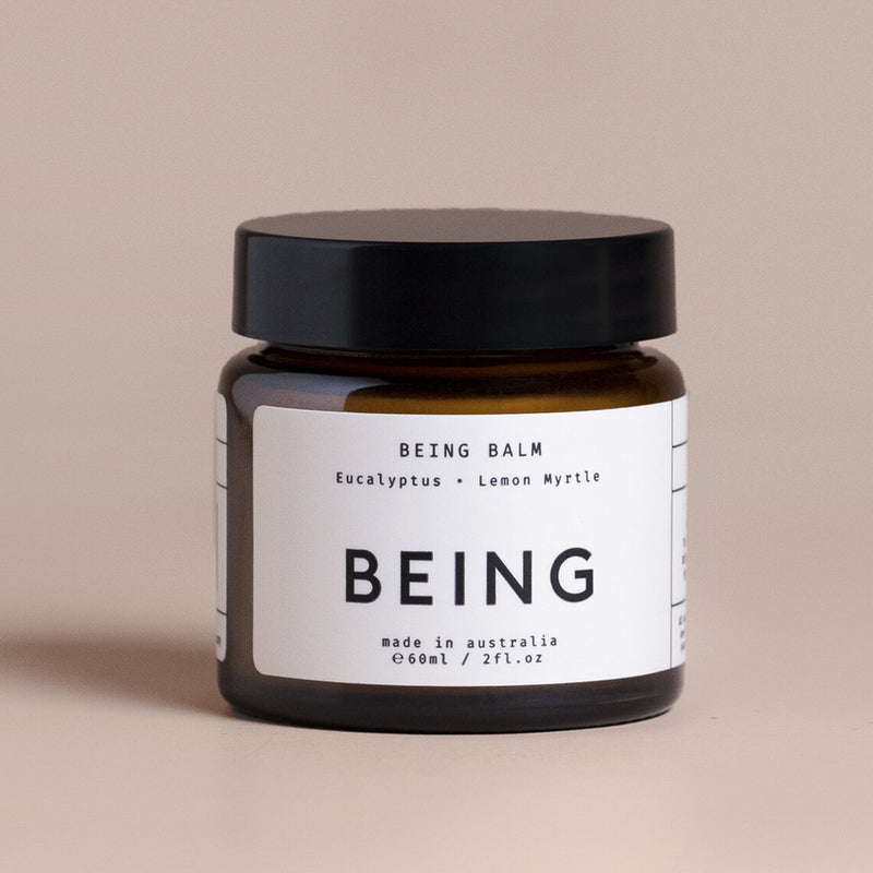 Being Skincare Being Balm is a 60ml brown jar with a black lid and "BEING" in large text. Made in Australia with natural eucalyptus and lemon myrtle, this body balm calms and moisturises your skin. Brand: Being Skincare.