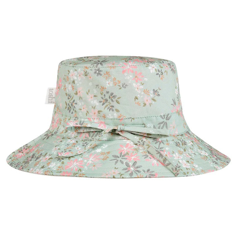 The Toshi Sunhat Athena Thyme is a light green adjustable baby hat with a pink and white floral pattern and a matching fabric bow on the front, inspired by Toshi swimwear.
