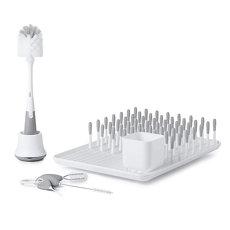 The OXO Tot Bottle & Cup Cleaning Set Grey by Oxo Tot includes a bottle brush with holder, drying rack with pegs, square basket, and two detail brushes—ideal for cleaning baby bottles and sippy cups.