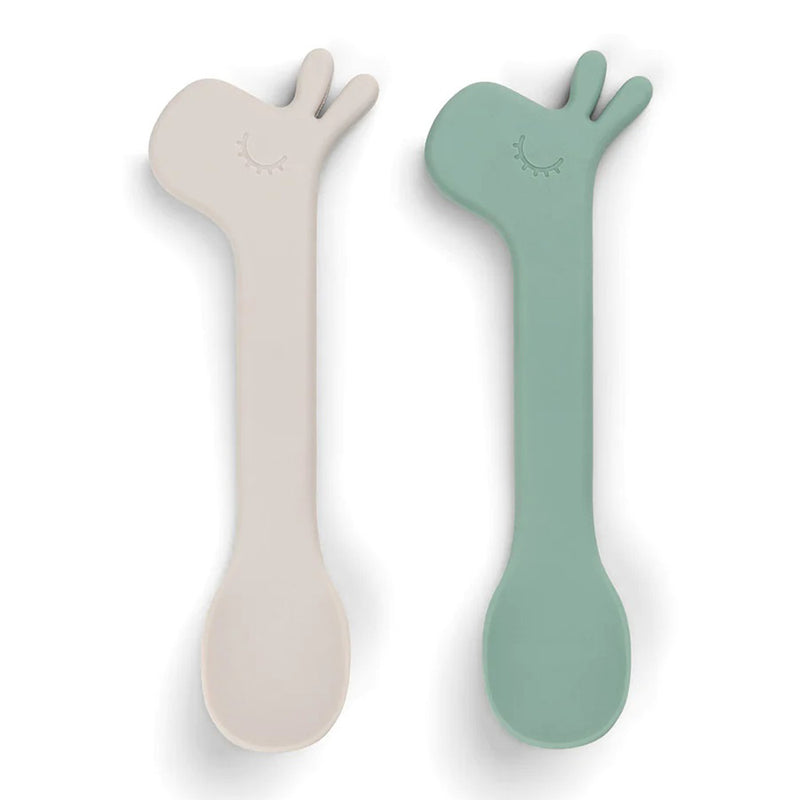 The Done By Deer Silicone Spoon 2-Pack Lalee Green includes two giraffe-head toddler spoons in beige and sage green, each with a cute closed-eye design and horn details—ideal for self-feeding.