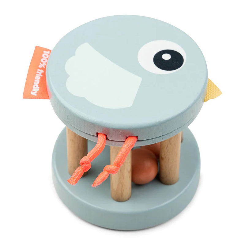 The Done By Deer Wooden Bell Rattle Birdee Blue is a round, light blue wooden bird-shaped rattle with grasping bars, an orange ball inside, string legs, a printed wing and eye, plus a "100% friendly" fabric tag—ideal for sensory play.