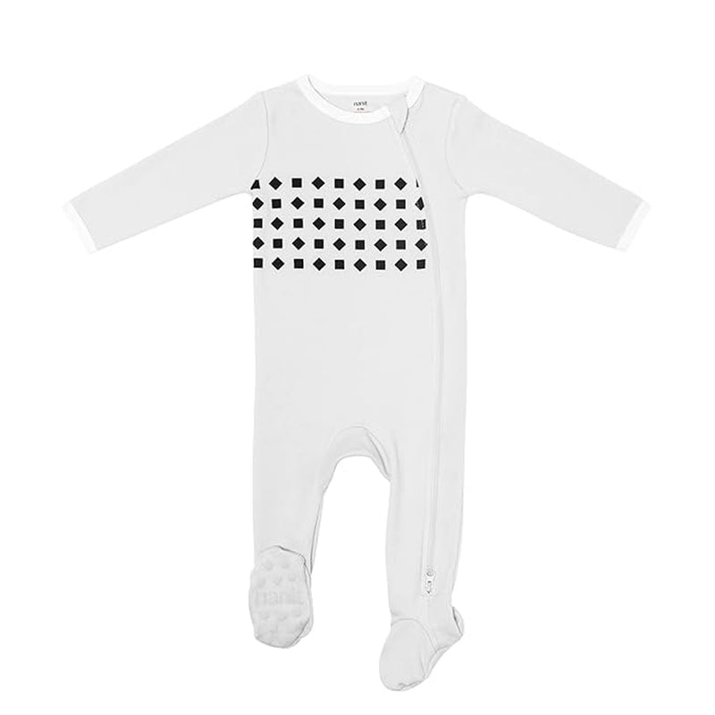 A white long-sleeve onesie with covered feet and black geometric shapes on the chest, featuring a diagonal zipper. Compatible with Nanit Breathing Wear Pajamas for real-time breathing alerts using a Nanit baby monitor.