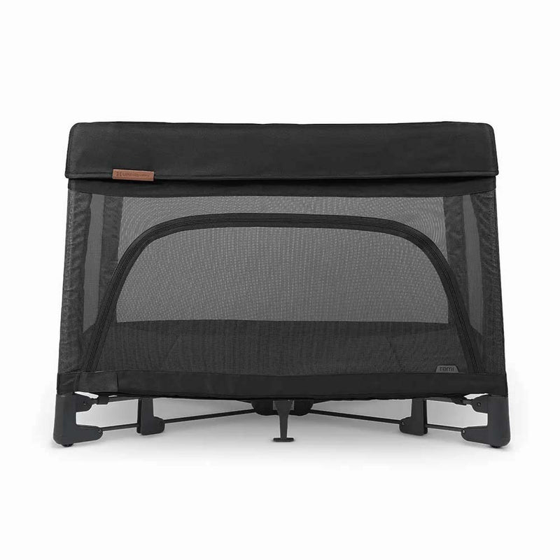 The UPPAbaby Remi Travel Cot by UPPAbaby is a black travel crib with mesh sides and a front zippered opening. It has a sturdy base, compact design, and breathable build, making it a perfect portable play yard for families on the go.
