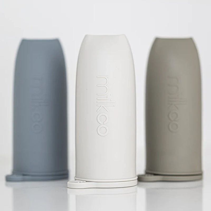 Three Milkco Breast Milk Ecopods River in blue, white, and taupe stand upright on a white surface, each made of food-grade silicone with "milkco" embossed—ideal reusable containers for breast milk storage.