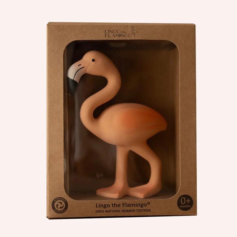 The Lingo The Flamingo Teether by Lingo The Flamingo is a pink rubber flamingo for ages 0+, displayed upright in a brown box with a clear window. The packaging states it soothes gums and is made from 100% natural rubber.