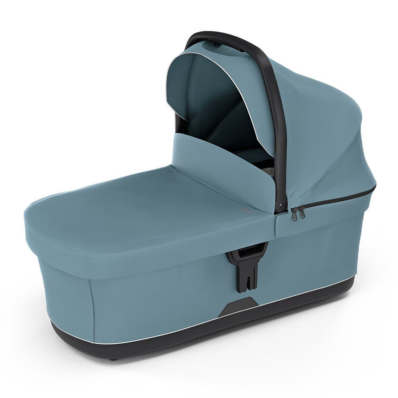 The Thule Urban Glide 3 Bassinet Mid Blue by Thule features a blue design with a black handle, canopy, and zippered sides. Designed for portability and comfort, it includes a ventilated mattress to enhance your baby's airflow.