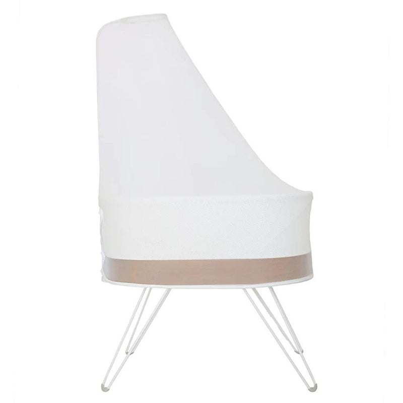 The Happiest Baby Snoo Mosquito Net is a modern white bassinet with a mesh canopy for mosquito protection, light wooden accent, and slender white metal legs, shown from the side against a plain background.