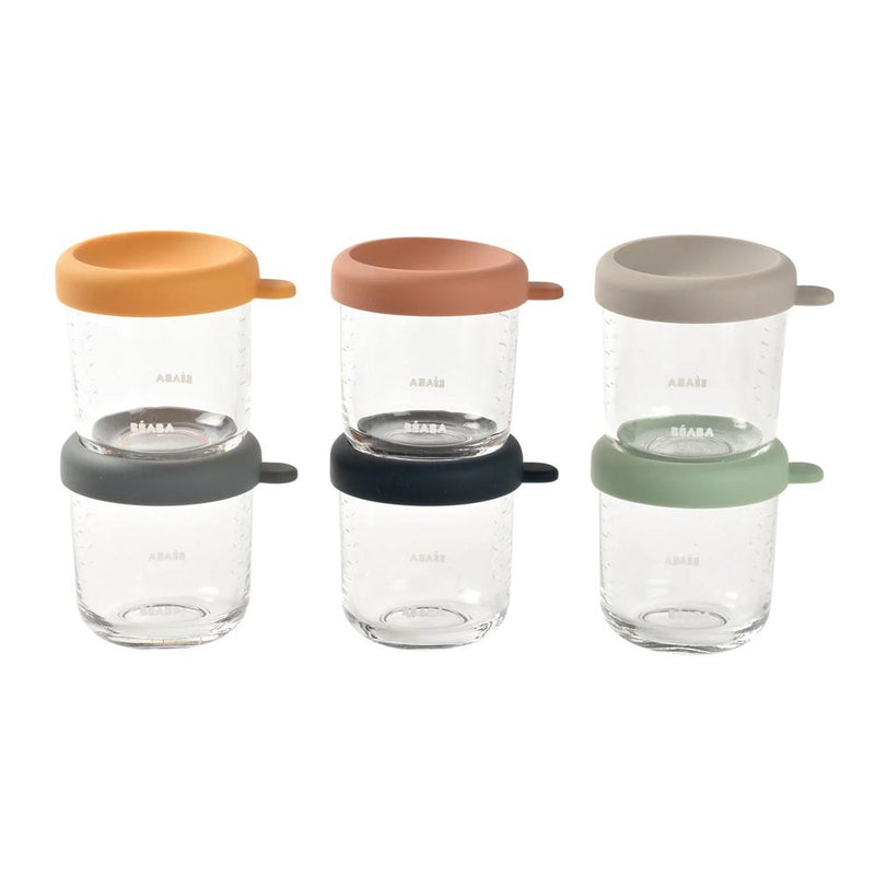 The Beaba Glass Portion Jars 250ml 6 Pack includes six clear jars with colorful lids—orange, brown, gray, dark gray, black, and green—each featuring small side handles. Perfect by Beaba for storing homemade baby food or purées.