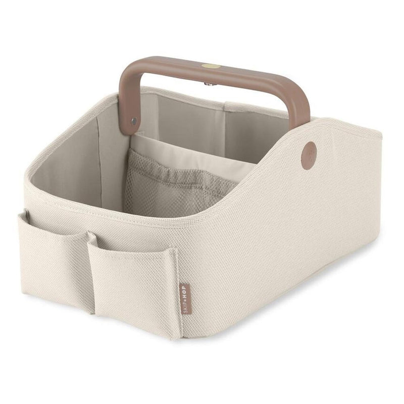 The Skip Hop Light Up Diaper Caddy Oat features a beige fabric, exterior pockets, large main compartment, interior dividers, and a sturdy brown handle for organized diaper storage.