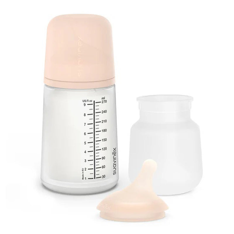 The Suavinex Zero Zero Baby Bottle Follow On Set 3M+ by Suavinex, with an anti-colic bottle, beige cap, silicone nipple, and extra transparent container, is displayed against a white background.