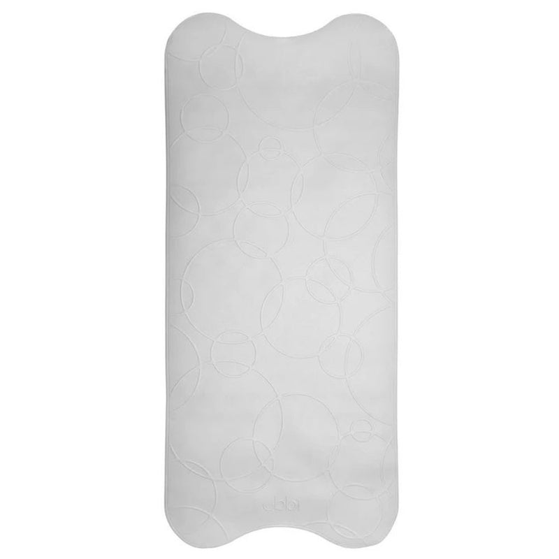 The Ubbi Bath Mat by Ubbi is a rectangular, light gray mat with rounded corners and an embossed circular pattern, providing a safe, non-slip surface for babies during bath time.