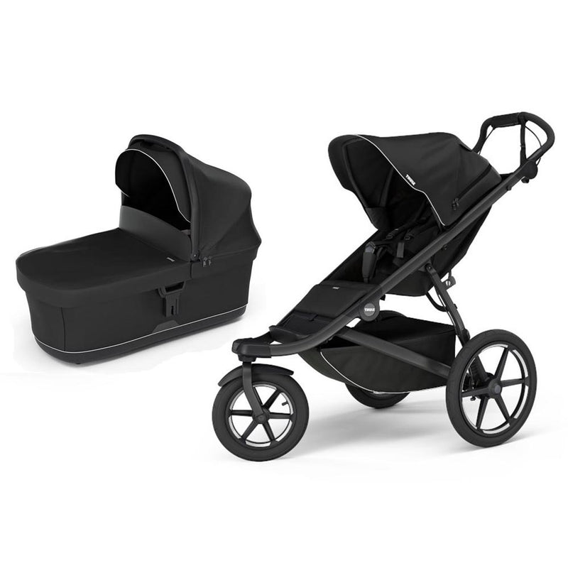 The Thule Urban Glide 3 Stroller + Bassinet Black by Thule is shown, featuring large wheels, a sleek modern look, and a matching black bassinet attachment—suitable for infants and toddlers.