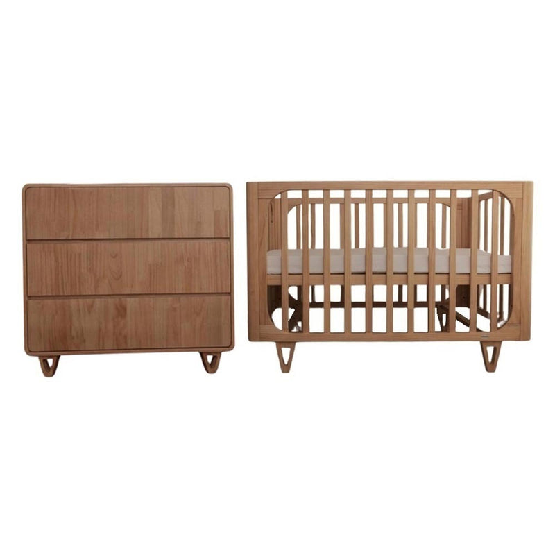 The Cocoon Vibe Cot + Dresser by Cocoon features a modern, minimalist design with light wood, vertical slats, angled legs, and three drawers—crafted from New Zealand pine wood.