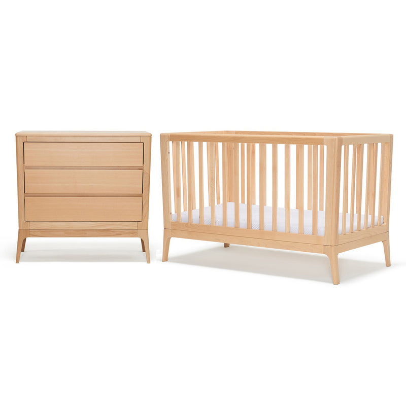 The BabyRest Amara Cot + Dresser set features light wood pieces with a white mattress, both crafted from natural timber for a modern, minimalist baby nursery – all by BabyRest.