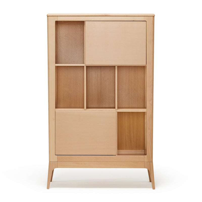 The BabyRest Amara Library by BabyRest is a modern cabinet made from European beech with a light natural finish, featuring an asymmetrical grid of open and closed compartments and sliding doors—perfect for any nursery.