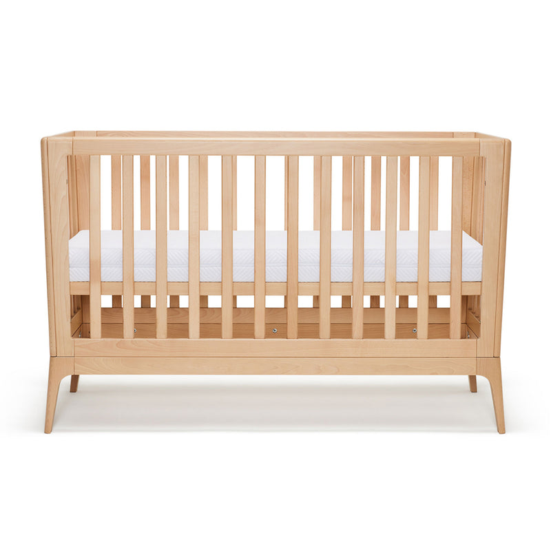 The BabyRest Amara Cot by BabyRest is a natural timber crib with light wood vertical slats and a white mattress, pictured on a plain white background—an elegant choice for your nursery furniture.