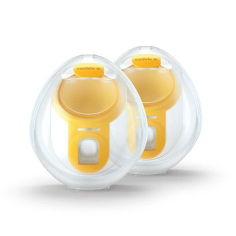 Two Medela Hands Free Collection Cups by Medela are displayed side by side on a white background. These yellow and white rounded cups have transparent covers and a small bottom opening for convenient breast milk collection.