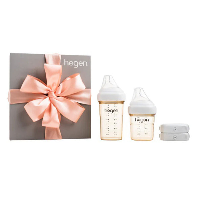 The Hegen PCTO Basic Starter Kit PPSU by Hegen features two anti-colic feeding bottles with white caps, two white accessories, and comes in a grey box tied with a pink satin bow—perfect for breast milk storage and feeding.