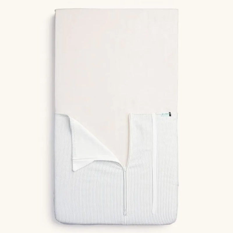 A folded ErgoPouch Tuck Sheet Bedside Sleeper Midnight Stripe by ErgoPouch, featuring white and gray stripes and a partially open zipper that reveals the inner lining—an ideal TOG-rated alternative to blankets for safe newborn sleep.
