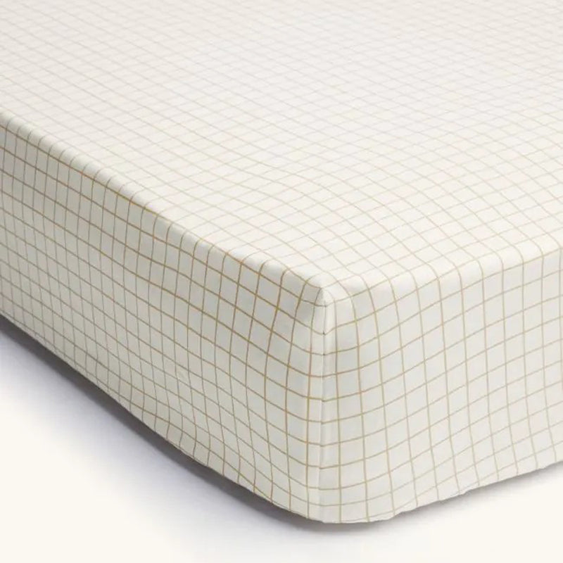 A close-up of the ErgoPouch 2 In 1 Waterproof Fitted Sheet Cot Caramel Grid, featuring a white background with a light brown grid pattern from ErgoPouch, ensuring safe and comfortable sleep for babies.