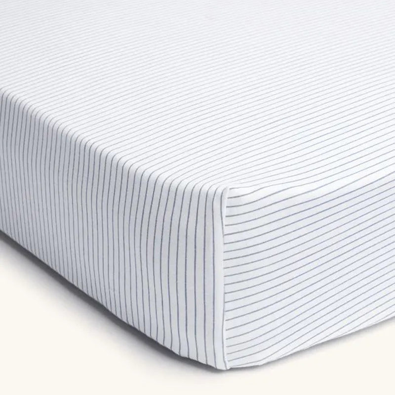 A close-up of the ErgoPouch 2 In 1 Waterproof Fitted Sheet Cot Midnight Stripe, featuring thin black stripes on white—ideal for safe baby sleep.