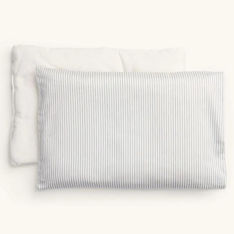 Two ErgoPouch pillows are side by side: one plain white organic cotton and one “ErgoPouch Pillow With Case Midnight Stripe” with vertical blue stripes, both designed for gentle toddler sleep support on a neutral background.