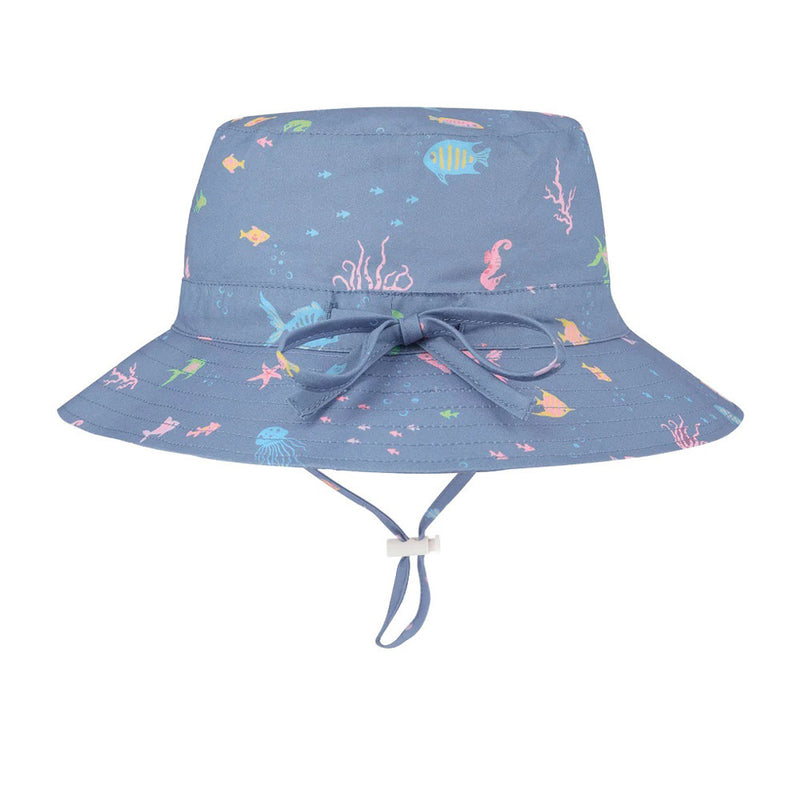 The Toshi Sunhat Dreaming/Seahorse by Toshi is a blue kids’ cotton hat with colorful sea creature prints, bow detail, adjustable chin strap, and UPF 50+ protection.