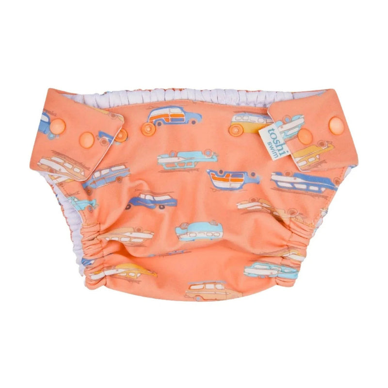 The Toshi Swim Baby Nappy Classic/Surfs Up by Toshi is an orange, reusable swim nappy with vibrant vintage cars, adjustable snaps, white elastic trim, waterproof protection, and UPF 50+ baby swimwear safety.