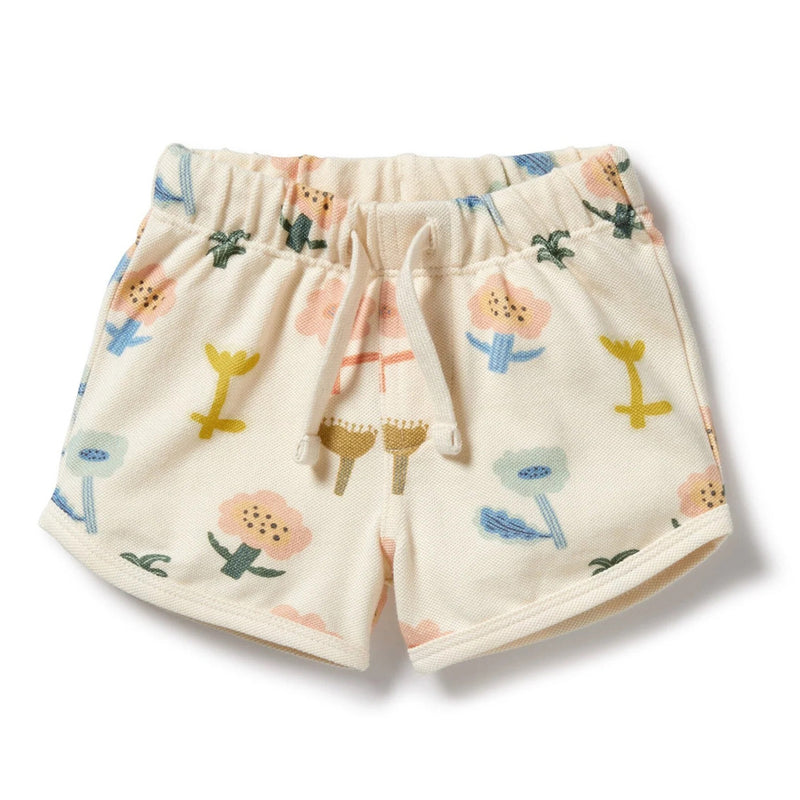 The Wilson & Frenchy Cookie Cut Organic Short features a cream-colored organic cotton design for toddlers, with an elastic waistband, drawstring, and a colorful floral print. GOTS certified for comfort and sustainability.
