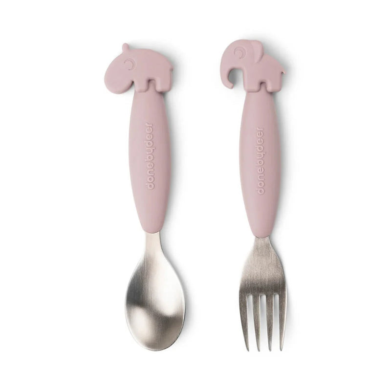 The Done By Deer Easy-Grip Spoon And Fork Set Deer Friends Powder is a pink toddler cutlery set with animal-shaped handles, featuring both a hippopotamus and an elephant, and “Done By Deer” printed on the handles for easy self-feeding.