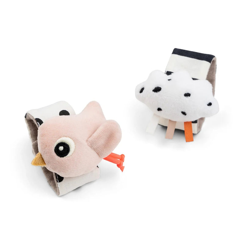 The Done By Deer Wrist Rattle Set 2-Pack Happy Clouds Powder features pink bird and white cloud designs on striped bands—ideal as soft newborn bracelets or sensory toys from brand Done By Deer.