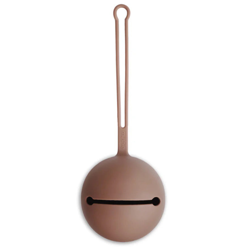 The Mushie Pacifier Case Cloudy Mauve by Mushie is a round, food-grade silicone case in brown with a slit opening and looped handle—perfect for storing pacifiers or small items and easily attaches to your stroller.