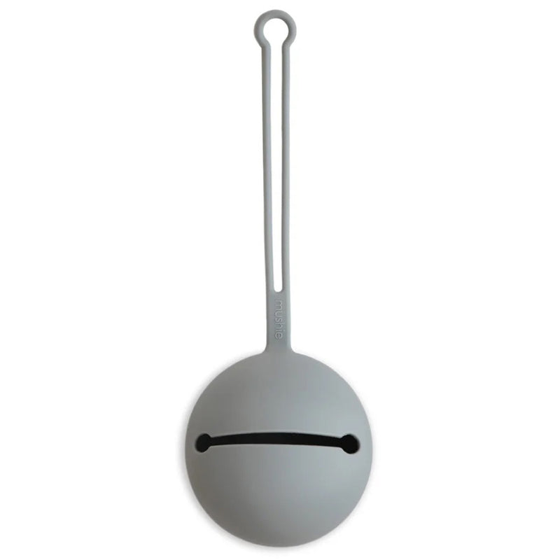 The Mushie Pacifier Case Stone by Mushie is a round, light gray silicone holder featuring a minimalist face design and a long looped handle, resembling Baymax from Big Hero 6, shown against a white background.